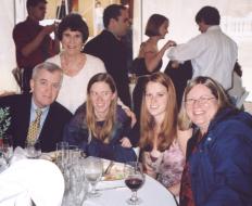 Lyn, Martha, Elizabeth, and Amy seated at the table, with Gail standing behind Lyn and Martha