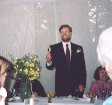 the father of the bride holds up his glass of champagne for a toast