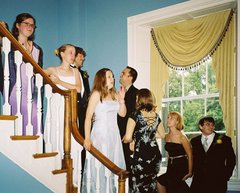 The bride and groom and ten of their young pose on the stairwell.