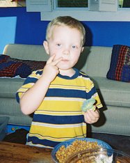 Boy Adam ponders his food.