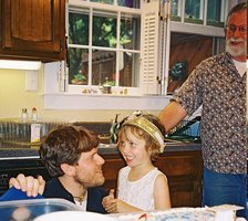 Steve bends to Hannah's level as they prepare for the cake.