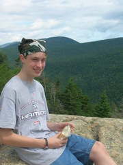 Phil seated on a rock, eating lunch