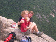 Jocelyn and Steve seated on a ledge, horsing around and eating lunch