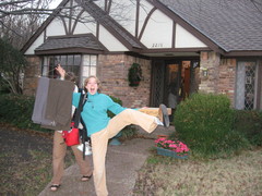 young woman kicking up one leg while holding some slacks on a coathanger